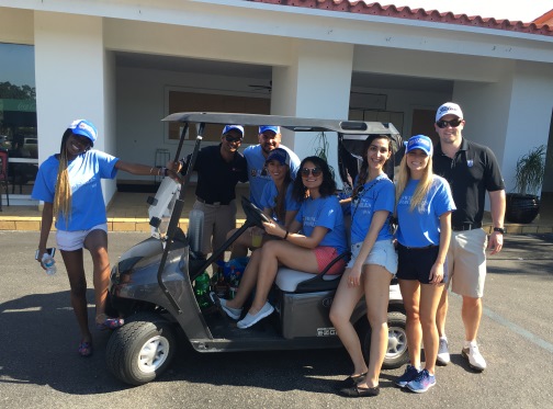 golf group gathered around golf cart