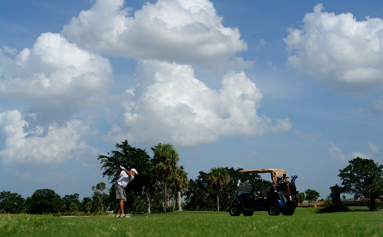 golfer teeing off on a clear day