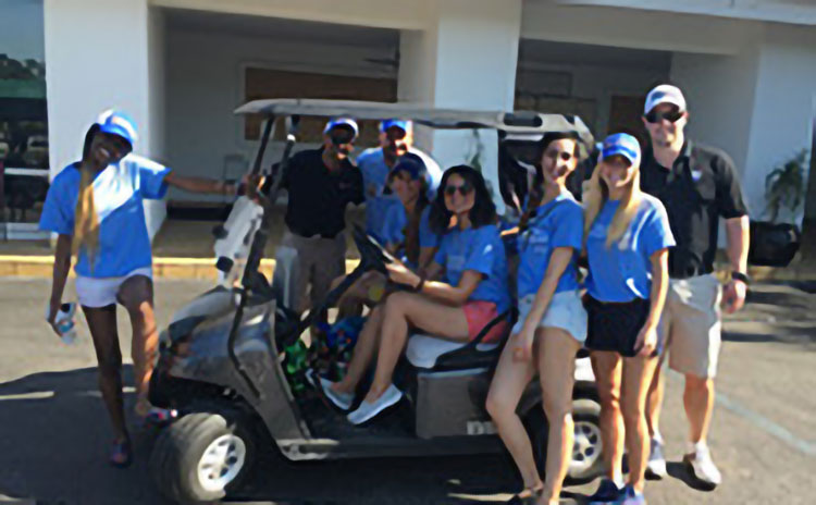 group of golfers gathered around a golf cart